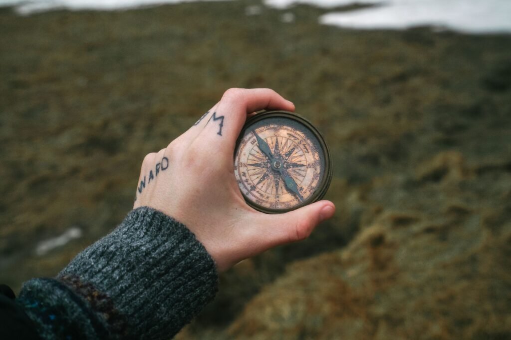 Hand holding a magnetic compass, the simple tool for testing a watch for magnetism